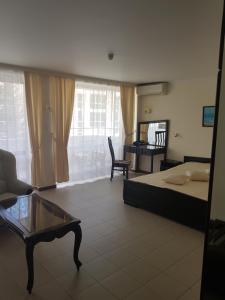阳光海滩克里苏拉酒店的一间卧室配有一张床、一张沙发和一张桌子