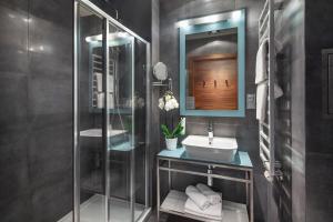 格丁尼亚Sea Premium Apartments的一间带玻璃淋浴和水槽的浴室