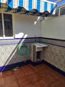 克莉丝蒂娜岛Chalet adosado con azotea andaluza y patio, junto a la playa的一间带水槽和瓷砖墙的浴室