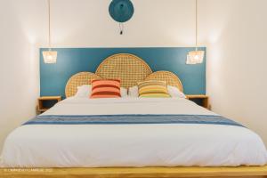 科托努L'imprévu L'annexe的一间卧室配有一张带三个枕头的大床