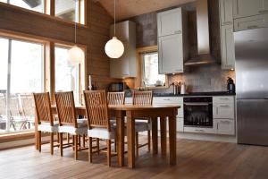 耶尔夫瑟Alpstigen 10A - Newly built sports lodge with amazing views的厨房配有木桌和一些椅子