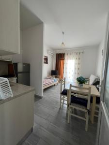维利波吉Bianca Apartments的厨房以及带桌椅的起居室。