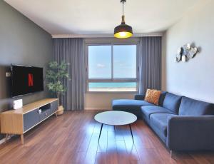 海法Luxury Suites by Notaly Ariel - Carmel Beach的客厅配有蓝色的沙发和电视