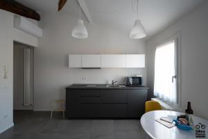 佩萨罗MONOLOCALE LE RONDINI centralissimo的白色的厨房配有水槽和微波炉