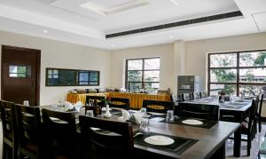 瓦拉纳西Treebo Trend Little Budhha的用餐室设有桌椅和窗户。