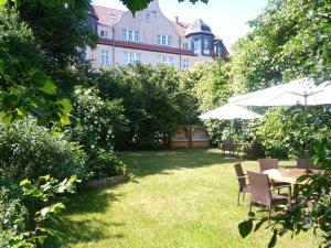 魏玛Hotel Hollerbusch的花园配有桌椅和遮阳伞。