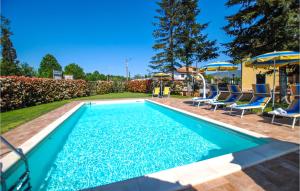 蒙特卡蒂尼泰尔梅2 Bedroom Beautiful Home In Montecatini Terme的一个带蓝色椅子和遮阳伞的游泳池