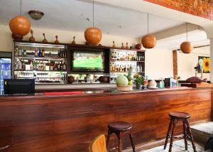 阿克拉Coconut Grove Regency Hotel的酒吧,带两个凳子和一台电视