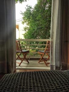 卡诺尼Beautifull And Airy Appartment Corfu Town的门廊上设有两把椅子的开放式门