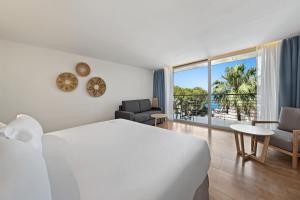 卡拉维尼耶斯Occidental Cala Viñas的酒店客房设有一张床,享有海景。