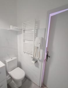 穆捷终点三村酒店的白色的浴室设有卫生间和窗户。