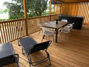塞尔瑟Luxury Mobile Houses Adria的木甲板配有桌椅和烧烤架