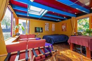 阿姆斯特丹Dreamtime Houseboat的客房拥有色彩缤纷的天花板,配有一张床和椅子