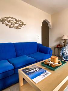 波多河丽Venetia apartment的客厅配有一张蓝色的沙发,配有一张桌子