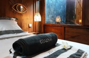 吉利阿尔Musa Bintang Villas and Bungalows Gili Air的一间酒店客房,配有一张带毛巾的床