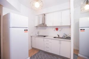 波尔图Travel & Live Marques的厨房配有白色橱柜和白色冰箱。