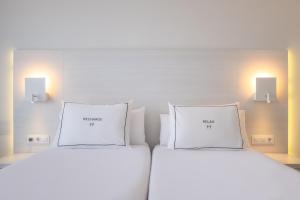 坎帕斯蒂利亚赫里奥马略卡酒店公寓的两张白色床,房间带两盏灯