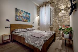 希贝尼克House Poletti的一间卧室设有一张床和石墙
