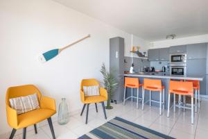 波尔尼谢Vue imprenable sur l'Ocean dans cet appartement pour six personnes的厨房配有橙色椅子和柜台