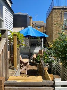 马盖特28 King Street的一个带蓝伞和桌椅的庭院