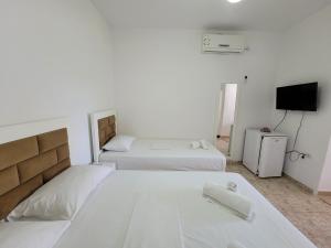 卡萨米尔Vila Geri的一间带两张床的卧室和一台电视