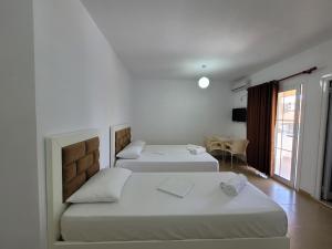 卡萨米尔Vila Geri的客房设有两张床、一张桌子和一扇窗户。