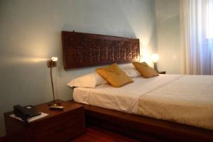 莱切卡萨德梅尔坎蒂区别墅酒店的一间卧室配有带白色床单和黄色枕头的床。