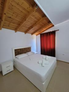 卡萨米尔Vila Geri的卧室配有一张白色大床和红色窗帘
