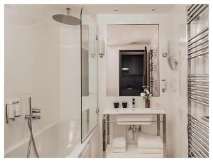 巴黎Le Rayz Vendome的白色的浴室设有水槽和淋浴。
