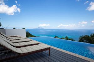 博瓦隆Paradise Heights Luxury Apartments & Villa的游泳池旁带躺椅的游泳池