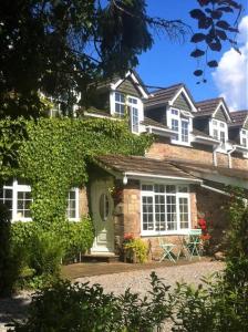 蒙默思Charming cottage within farmhouse的砖屋,设有绿门和白色窗户