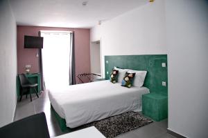 波塔莱格雷Ammaia AL的一间卧室配有一张大床和绿色床头板