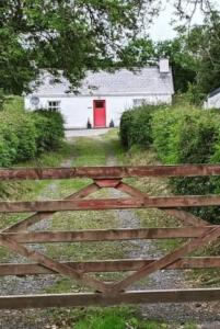 莱特肯尼Butler's Cottage, Letterkenny的木门后面的带红色门的谷仓