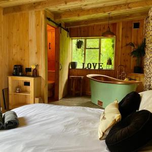 蒙默思Bee Bole Cabin的一间卧室配有一张床和浴缸