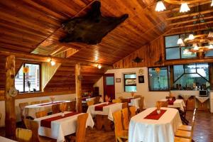 西蒙Vila Maria Bran的餐厅设有桌椅和木制天花板。