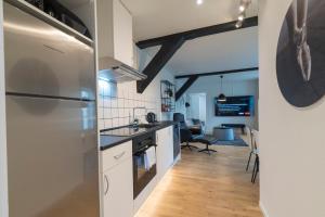 森讷堡Guesthouse的厨房配有白色橱柜和冰箱。