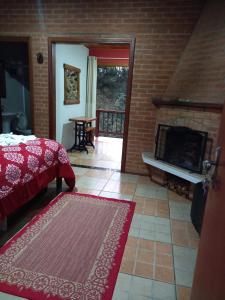 蒙特韦尔迪Caminho do Sol的一间卧室配有一张床和一个壁炉