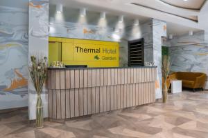 豪伊杜索博斯洛Thermal Hotel Garden的酒店大堂设有黄色标志和柜台