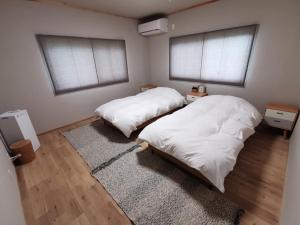 鸣门市Takeshima - Vacation STAY 61918v的两张位于带两扇窗户和地毯的客房内的床铺