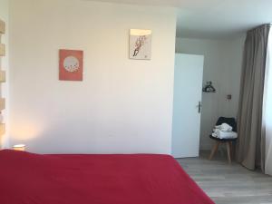 卢布雷萨克Hôtel Restaurant - Le Vieux Pigeonnier的一间卧室设有红色的床和白色的墙壁