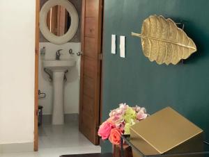 圣地亚哥洛斯卡巴Oasis Palma Real santiago, Republica Dominicana的一间带水槽和鲜花桌的浴室