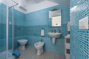 圣维托罗卡波Le case di San Vito的蓝色瓷砖浴室设有卫生间和水槽