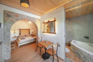 KrásionKrassopsychia Apartments的一间卧室配有一张床、一张桌子和一个浴缸