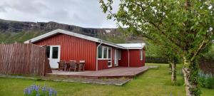 帕特雷克斯菲厄泽Ægisholt privete house with hot tub的一间红色小屋,在院子里设有木甲板
