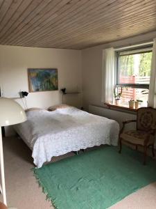 兰伯尔Maren's apartment on Randbøl Heath的卧室配有床、椅子和窗户。