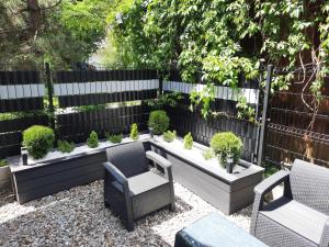 波罗宁Warsztat Apartamenty Stare Izby的花园设有两把椅子和种有植物的长凳