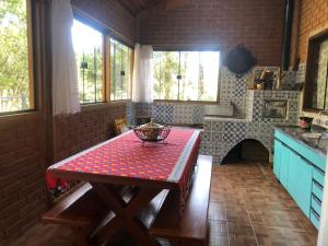 贡萨尔维斯Casa de Campo Meu Pequeno Paraíso的厨房配有一张带红色桌布的桌子