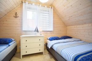 波别罗沃Przystanek Pobierowo的一间卧室设有两张单人床和一个窗户。