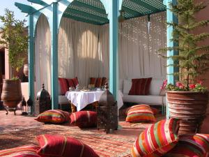 马拉喀什里亚德克尼莎摩洛哥传统庭院的配有桌椅和桌子的房间
