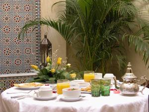 马拉喀什里亚德克尼莎摩洛哥传统庭院的一张带食物和饮料的白色桌子